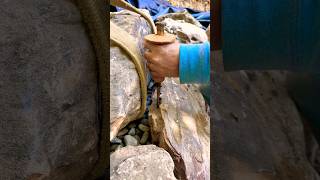 Chiseling a rock to make the perfect fit riverbedbuilders gardendesign pondbuilders [upl. by Alaekim]