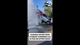 Car suspended in air by water gushing from fire hydrant after crash [upl. by Nazus]