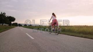 Young Woman Riding Bicycle Summer Dress Field Sunset  Stock Footage [upl. by Annamaria]